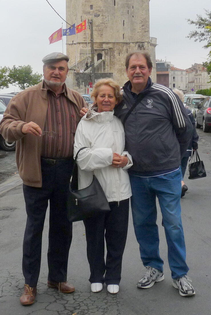 René Pesenti, à gauche, et Urbain Philippot, à droite, debout dans une rue, une tour médiévale en arrière-plan